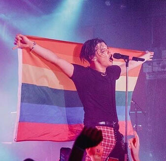 Yungblud holding up a rainbow flag